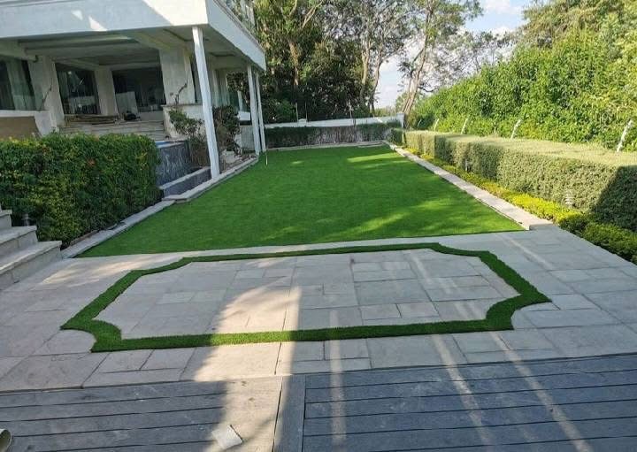 Paved courtyard with a shaped lawn inlay and turf edging
